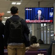 People watch a TV screen showing South Korean President Yoon Suk Yeol's televised briefing at a bus terminal in Seoul, South Korea, Tuesday, Dec. 3, 2024. (AP Photo/Ahn Young-joon)